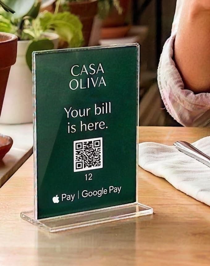 Casa Oliva acrylic QR sign standing on a restaurant table